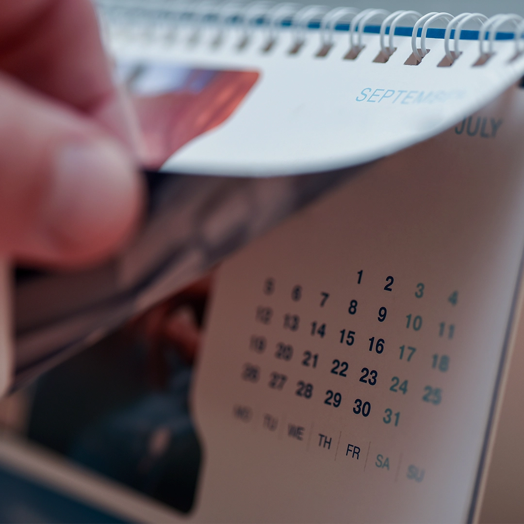 Mão mostrando calendário branco com linhas pretas. Para exemplificar como as datas comemorativas podem alavancar as vendas de seu negócio.