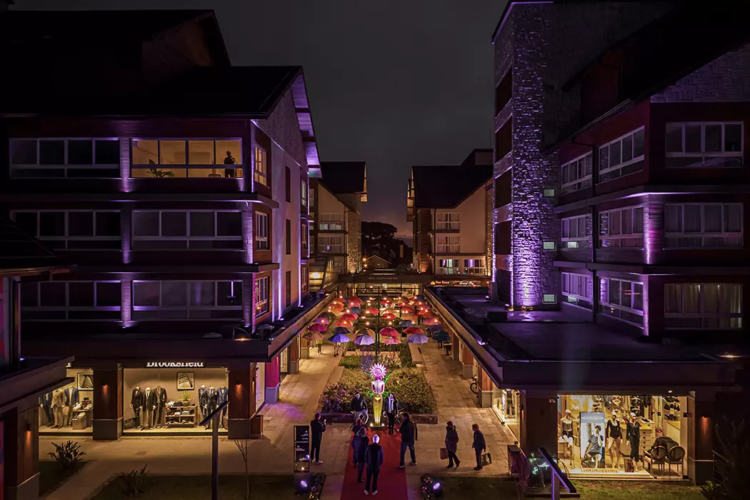 Complexo Vita Bpulevard que alia compras, moradia e office. Imagem do mall durante a noite, com iluminação violeta.